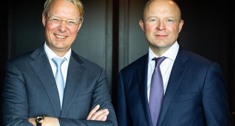 two men in suits posing for a picture